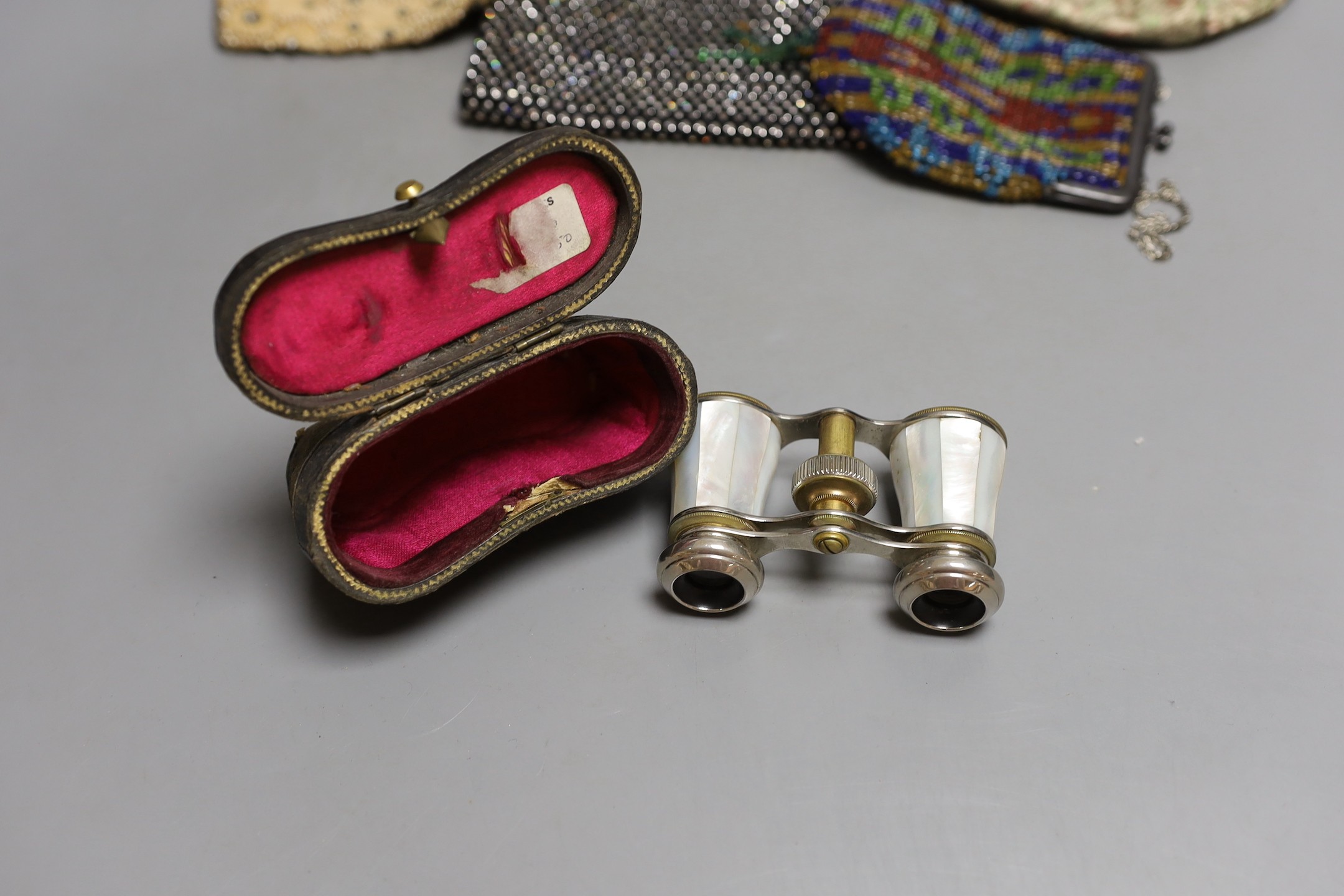 Four assorted lady's evening bags and a pair of cased opera glasses.